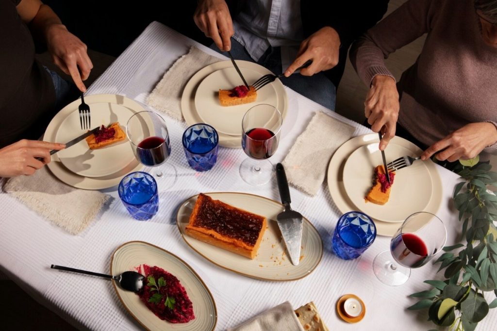People sharing dessert and wine at a dining table, celebrating a special occasion together.