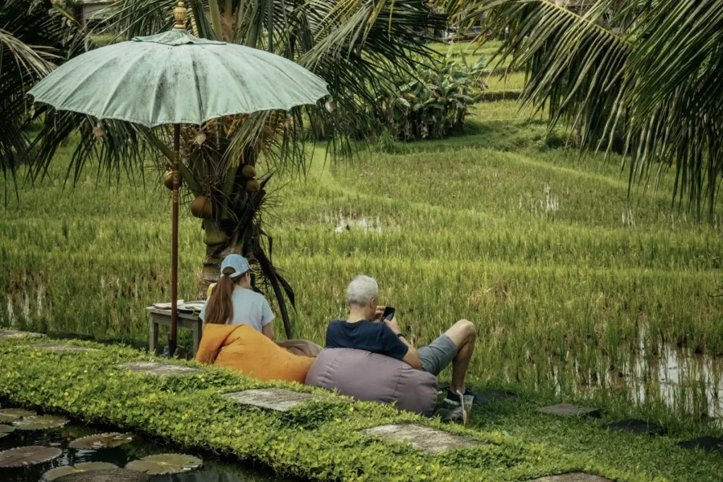 Couple relaxing beside Ubud rice fields, enjoying a peaceful setting during their honeymoon.