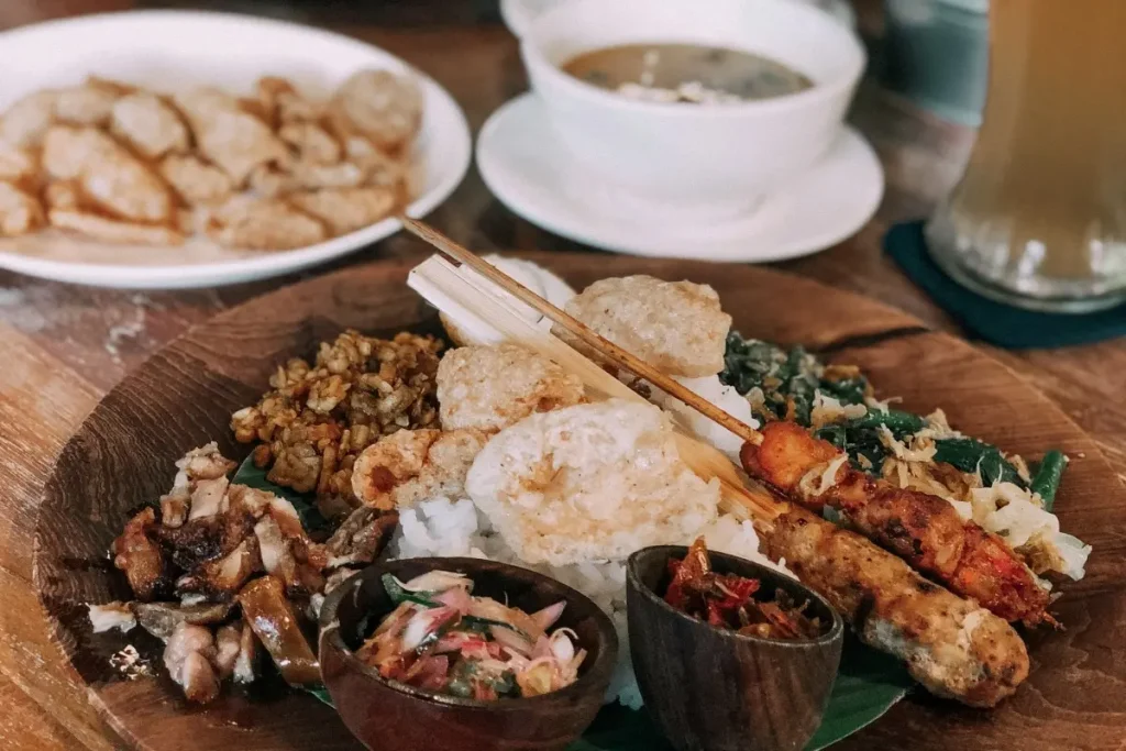 Traditional Balinese meal with rice, satay, vegetables, and sambal, representing the best food in Ubud.