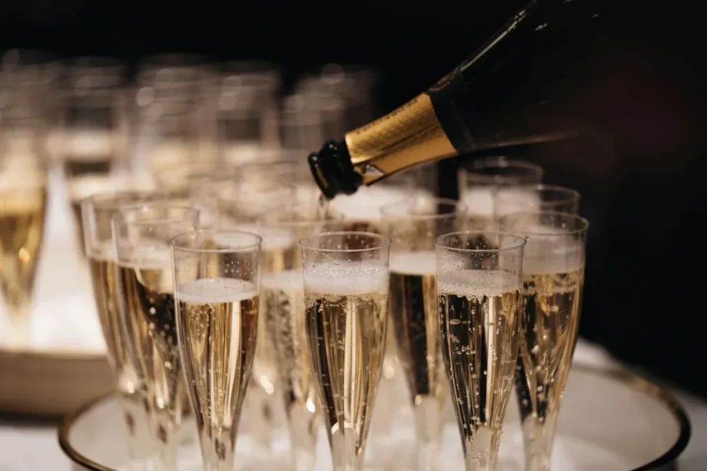 Champagne is poured into elegant glasses, showing why it is valued in luxury dining and special celebrations.