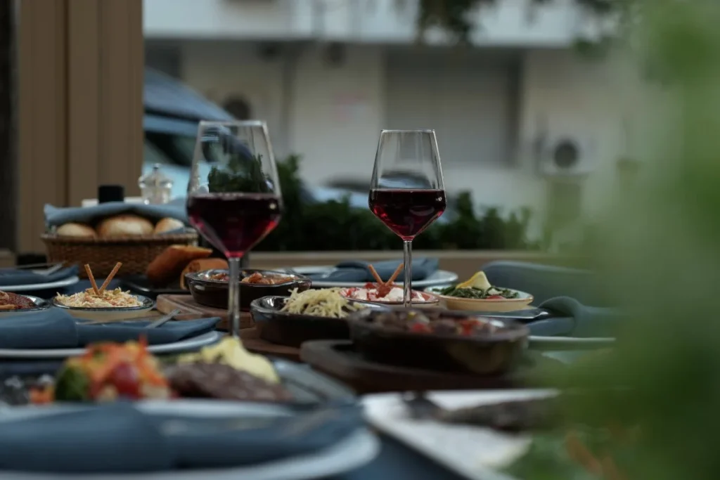 Romantic dinner table with wine and shared dishes, showing a cozy dining experience for couples in Ubud.