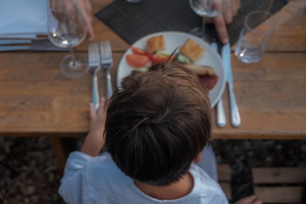 Child enjoying a family meal at a fine dining restaurant in Ubud, showing a relaxed family dining experience.