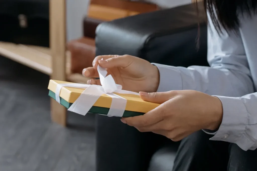 A person holds a wrapped gift box, representing an experience gift chosen to create meaningful memories.